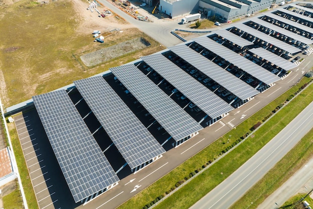 Aerial view of solar panels installed as shade roof over parking lot with parked cars for effective generation of clean electricity Photovoltaic technology integrated in urban infrastructure