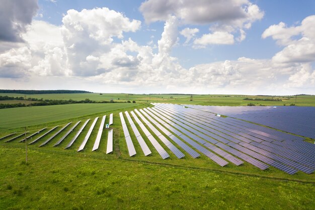 Aerial view of solar power plant on green field. Electric panels for producing clean ecologic energy.