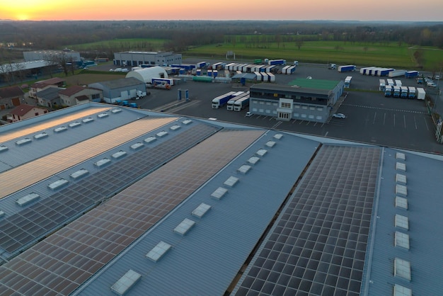 Aerial view of solar power plant with blue photovoltaic panels mounted on industrial building roof for producing green ecological electricity Production of sustainable energy concept