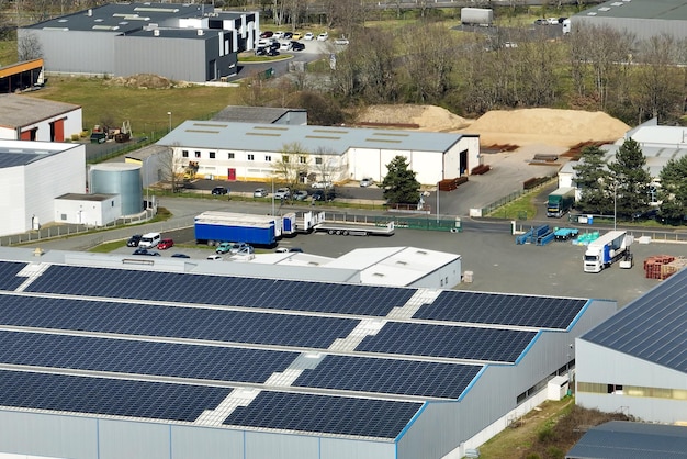 Aerial view of solar power plant with blue photovoltaic panels mounted on industrial building roof for producing green ecological electricity Production of sustainable energy concept