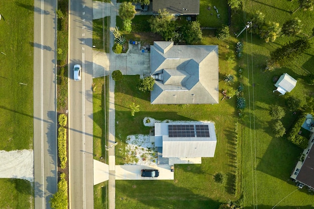 Aerial view of street traffic with driving cars in small town America suburban landscape with private homes between green palm trees in Florida quiet residential area