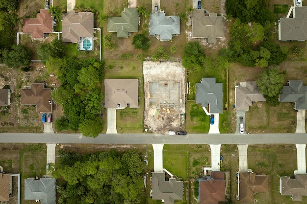 Aerial view of suburban private house wit wooden roof frame under construction in Florida quiet rural area