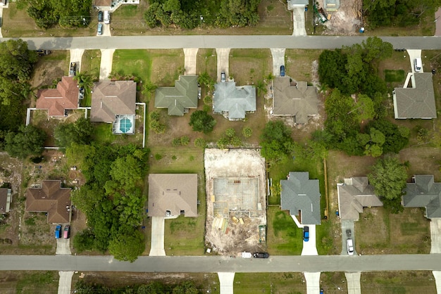 Aerial view of suburban private house wit wooden roof frame under construction in Florida quiet rural area