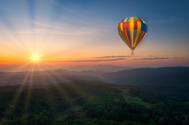 Aerial view of sunrise with ballon over mountian and pine tree in Chiang Mai Province Thailand