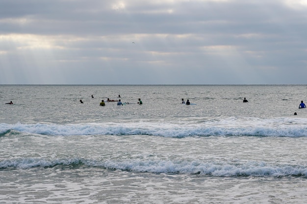 Aerial view of surfers on their board waiting the waves during sunset