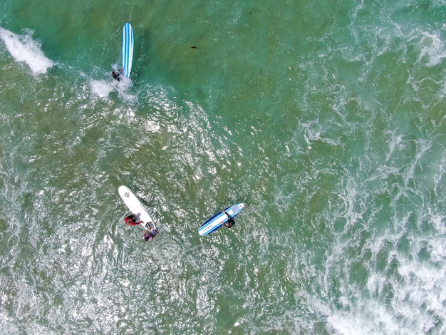 Aerial view of surfers waiting and paddling to the waves in blue water La Jolla California USA