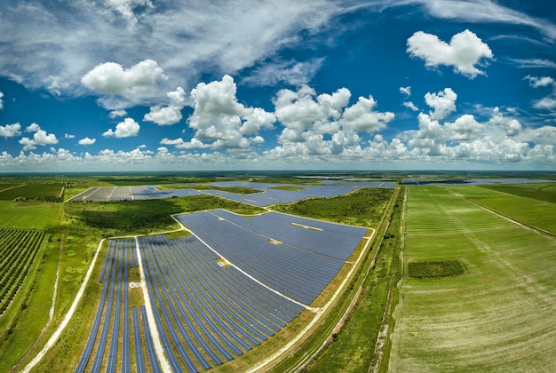 Aerial view of sustainable electric power plant between agricultural farm fields with solar photovoltaic panels for producing clean electrical energy Renewable electricity with zero emission concept