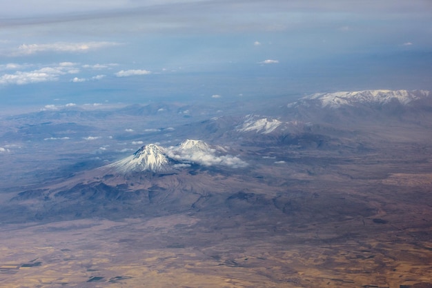 Aerial view through clouds Airplane view of mountains with glacier