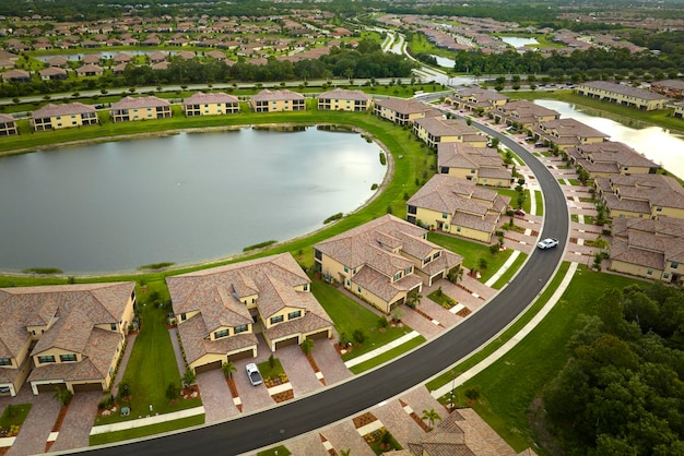 Aerial view of tightly located family houses with retention ponds to prevent flooding in Florida closed suburban area Real estate development in american suburbs