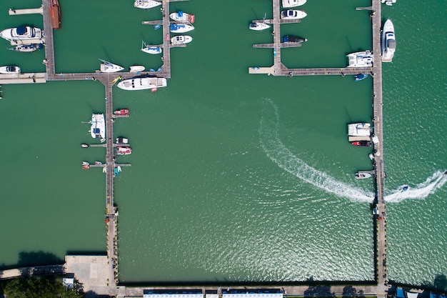 Aerial View Top down Drone shot of Yacht and sailboat parking in marina Transportation and travel background Beautiful sea in summer season