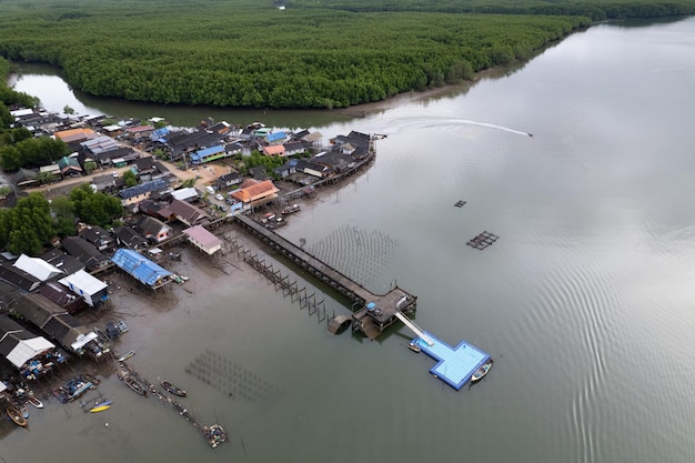 Aerial view top down of the fisherman village with fishing boats and house roof at the pier in Phangnga Thailand high angle view