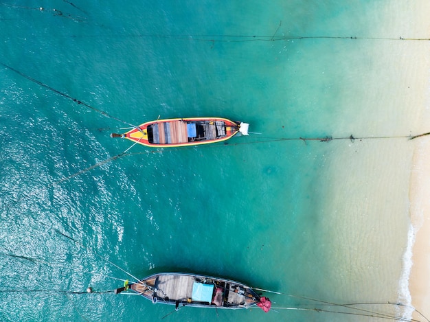 Aerial view top down longtail fishing boats at the sea in Phuket Thailand