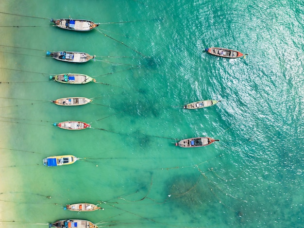 Aerial view top down longtail fishing boats at the sea in Phuket Thailand