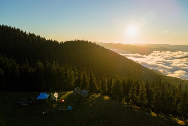 Aerial view of tourist camping tents on mountain campsite at bright sunny evening Active tourism and hiking concept