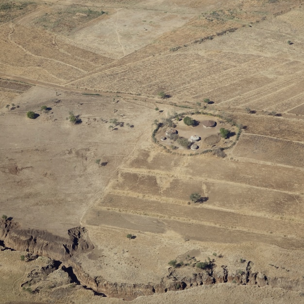 Aerial view on a traditional masai village in the dry plain around serengeti