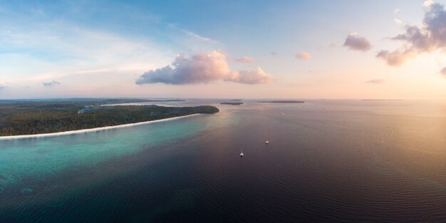 Aerial view tropical beach island reef caribbean sea at sunset. 