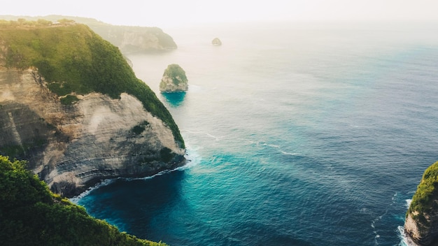 Aerial view of tropical beach with high cliffs and blue sea water in the morning Nusa Penida island Bali