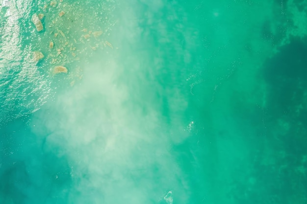 An aerial view of turquoise ocean waters blending with a sandy shoreline capturing the serene mesmerizing beauty of the coast