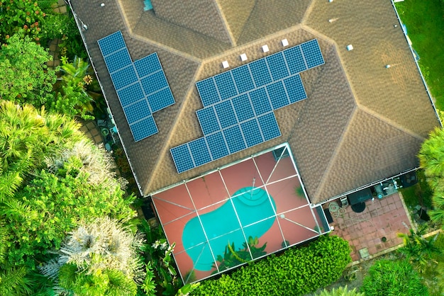 Aerial view of typical american building roof with rows of blue solar photovoltaic panels for producing clean ecological electric energy Renewable electricity with zero emission concept