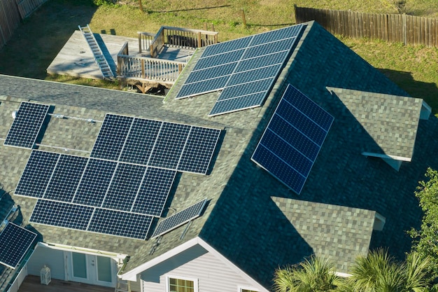 Aerial view of typical american building roof with rows of blue solar photovoltaic panels for producing clean ecological electric energy Renewable electricity with zero emission concept