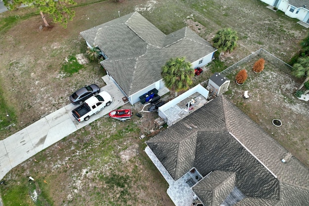 Aerial view of typical contemporary american private house with roof top covered with asphalt shingles and green lawn on yard