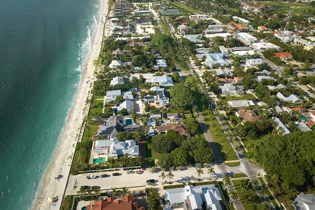 Aerial view of wealthy waterfront neighborhood Expensive mansions between green palm trees on Gulf of Mexico shore in island small town Boca Grande on Gasparilla Island in southwest Florida USA