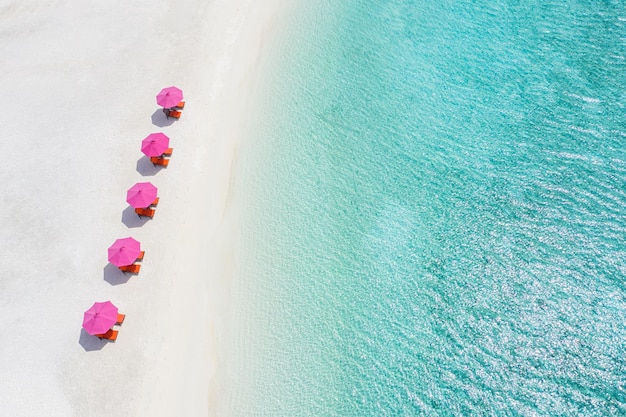 Aerial view of white sandy beach loungers beach umbrella close to turquoise sea water and lagoon