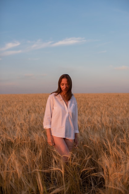 Aerial view of woman lying in the yellow field of wheat