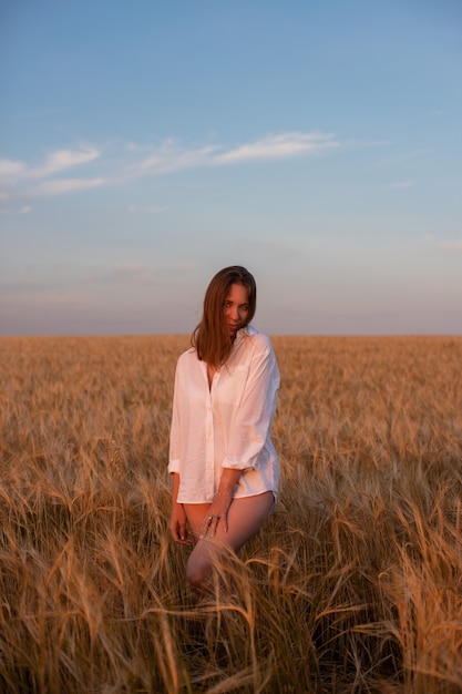 Aerial view of woman lying in the yellow field of wheat