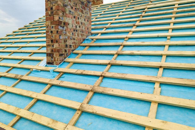 Aerial view of a wooden roof frame of brick house under construction.