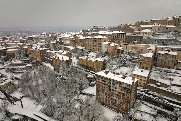 Aerial winter landscape of dense historic center of Thiers town in PuydeDome department AuvergneRhoneAlpes region in France Rooftops of old buildings and narrow streets at snowfall