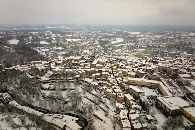 Aerial winter landscape of dense historic center of Thiers town in PuydeDome department AuvergneRhoneAlpes region in France Rooftops of old buildings and narrow streets at snowfall