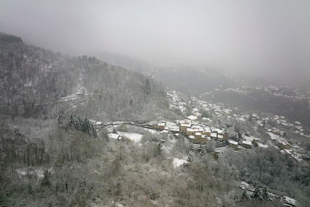 Aerial winter landscape of dense historic center of Thiers town in PuydeDome department AuvergneRhoneAlpes region in France Rooftops of old buildings and narrow streets at snowfall