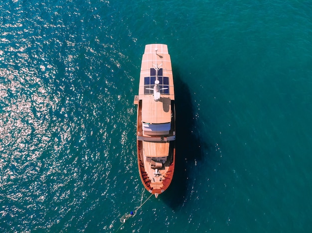 Aerial wonderful top view of a colorful interesting sail boat staying at the sea