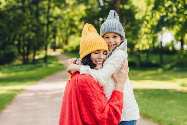 Affectionate good looking young mother embraces her single daughter