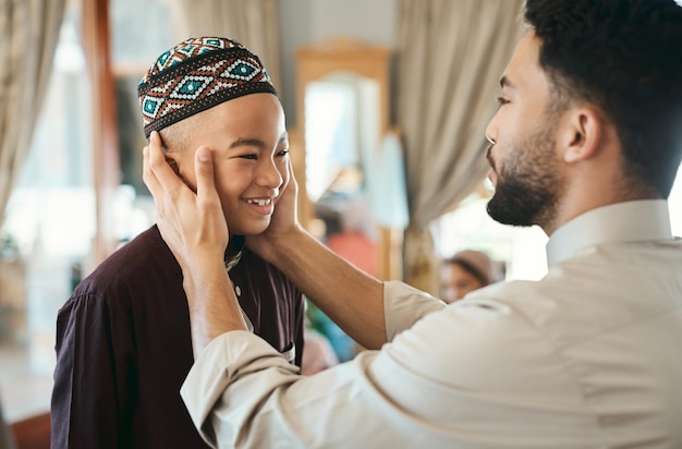 Affectionate loving and caring Muslim father and son talking and bonding on Eid holiday Cute smiling and happy Islamic child listening to advice from dad while wearing a traditional outfit