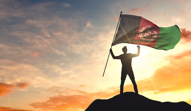 Afghanistan flag being waved by a man celebrating success at the top of a mountain 3D Rendering