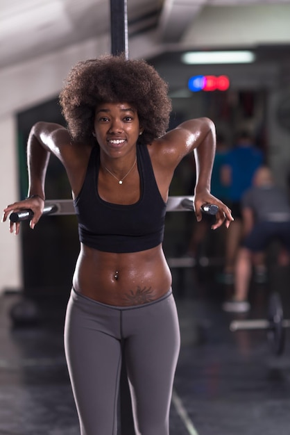 african american athlete woman workout out arms on dips horizontal parallel bars Exercise training triceps and biceps doing push ups