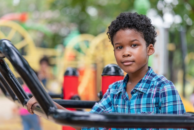 African American boy look at camera while exercise at playground in the park