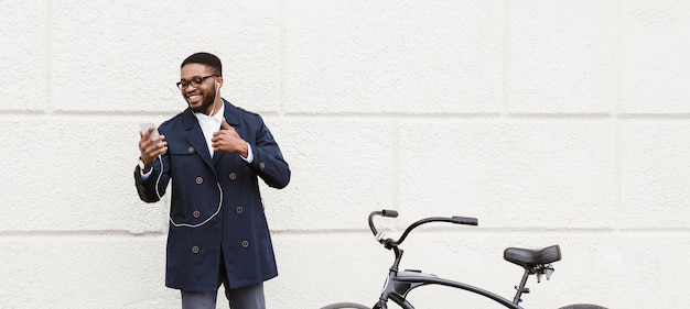 African american businessman have video call on the way to office waving at phone screen standing