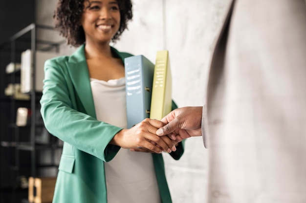 African american businesswoman and businessman shaking hands in modern office