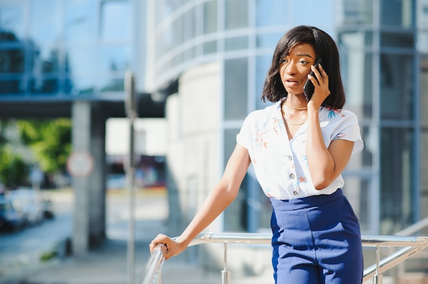 African American businesswoman using mobile phone on street