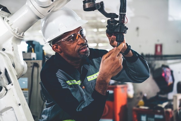 African American factory worker working with adept robotic arm