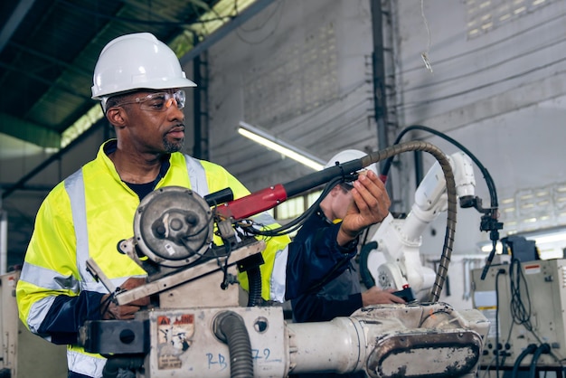 African American factory worker working with adept robotic arm