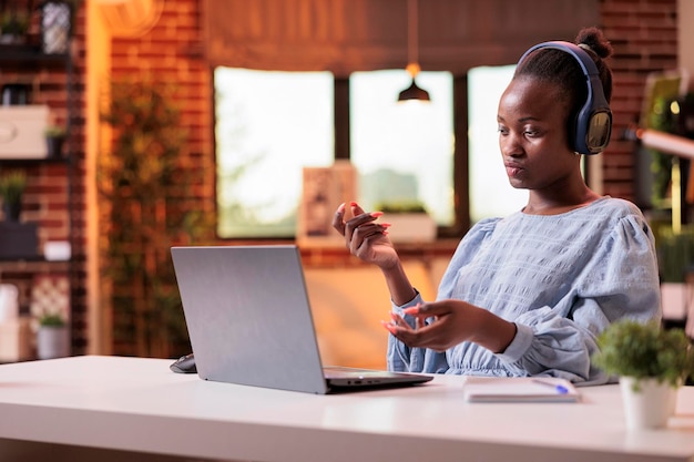 African american female freelancer talking with client on online videocall in modern home office. Videoconference meeting with company remote team, businesswoman on teleconference