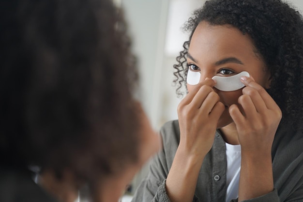 African american girl apply cosmetic under eye patches for facial skin Skincare beauty routine