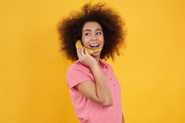 African american girl posing with banana isolated.