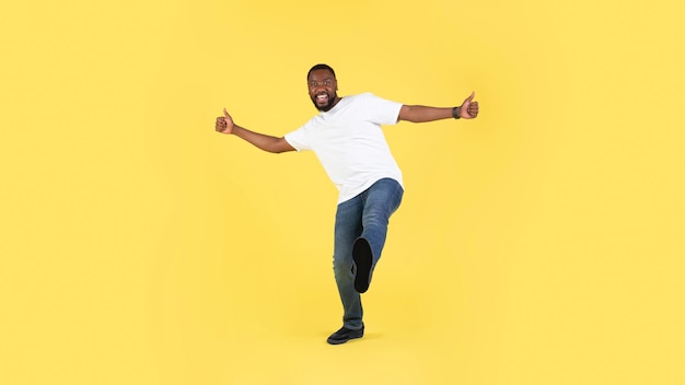 African American Guy Gesturing Thumbs Up Over Yellow Background Panorama