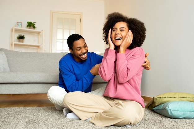 African American Husband Tickling Wife Playfully Having Fun At Home