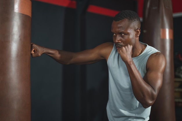 African American man boxer exercise boxing workout with punching bag in fitness gym